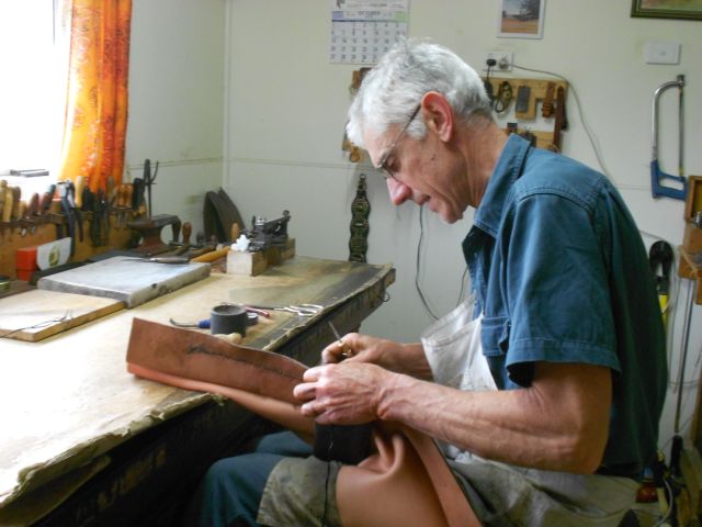 Mark Porter hand-sewing, with black-waxed thread, at his work-bench in Currawarna